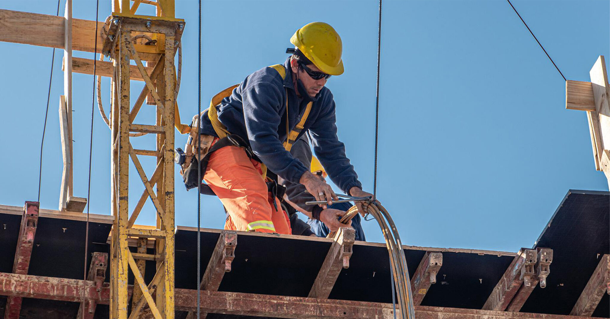 Metro Areas add construction jobs | A construction worker working on an elevated platform