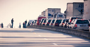 Work-zone crashes are on the rise | Pictured: Traffic jam with people standing in the road next to the traffic jam