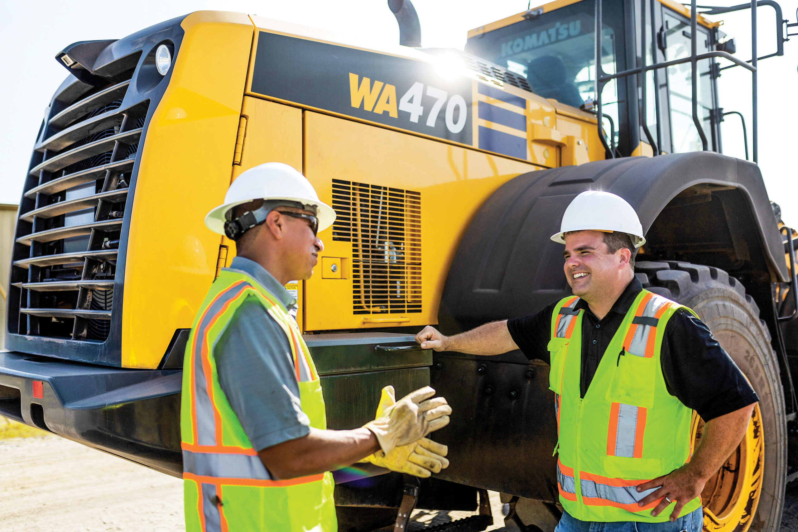 Two Construction Workers talking in front of Komatsu WA470 Wheel Loader