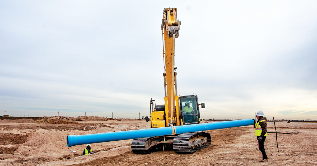 Industry Outlook The Bipartisan Infrastructure Law | a Komatsu excavator holding up a pipe