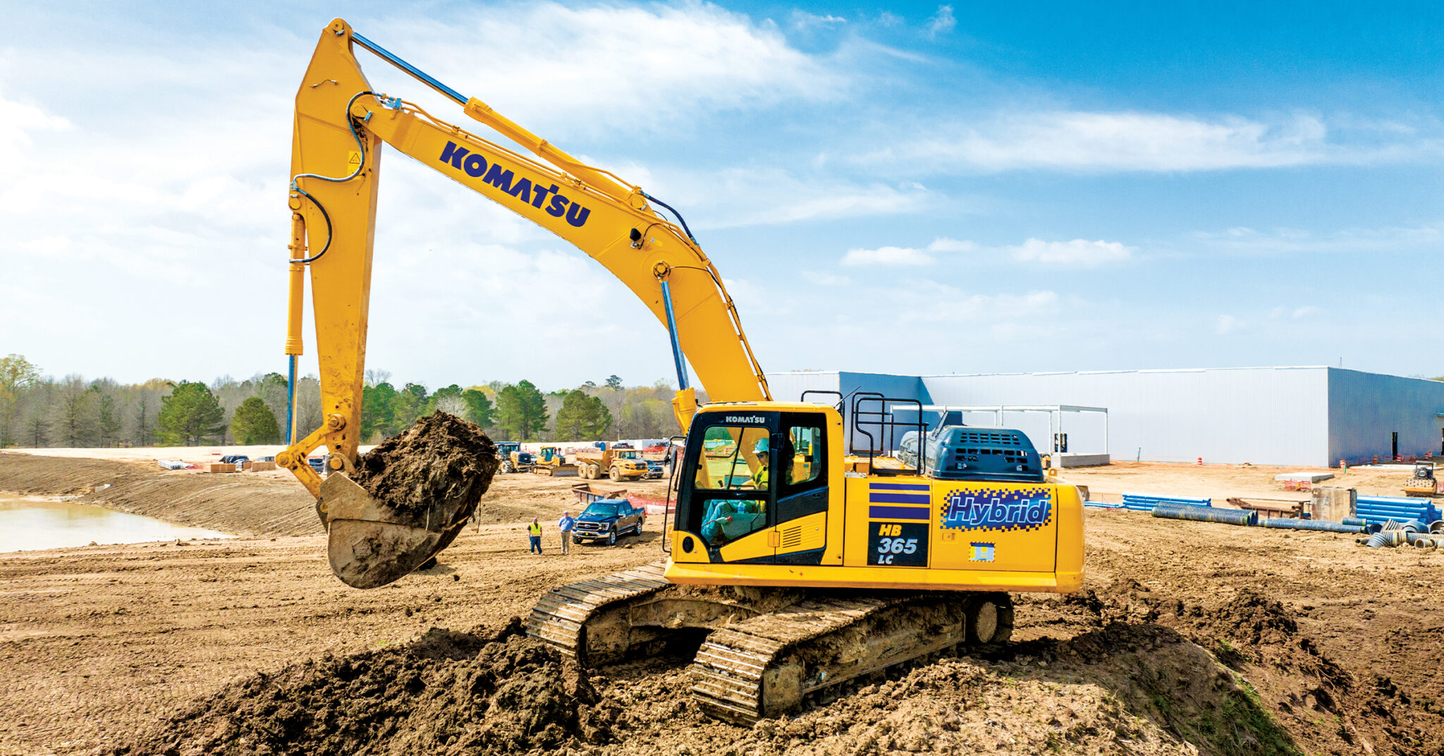 An image of an operator swinging a Komatsu HB365LC-3 excavator to load a haul truck