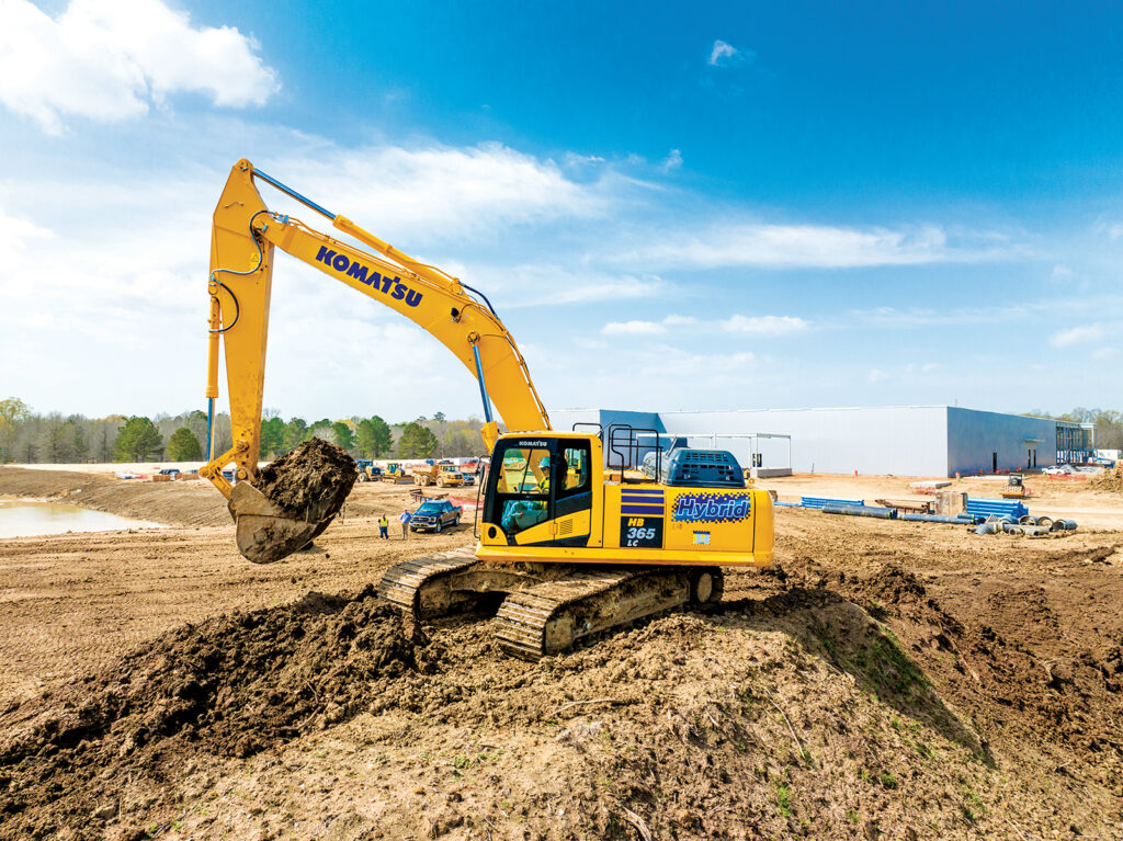 An image of an operator swinging a Komatsu HB365LC-3 excavator to load a haul truck