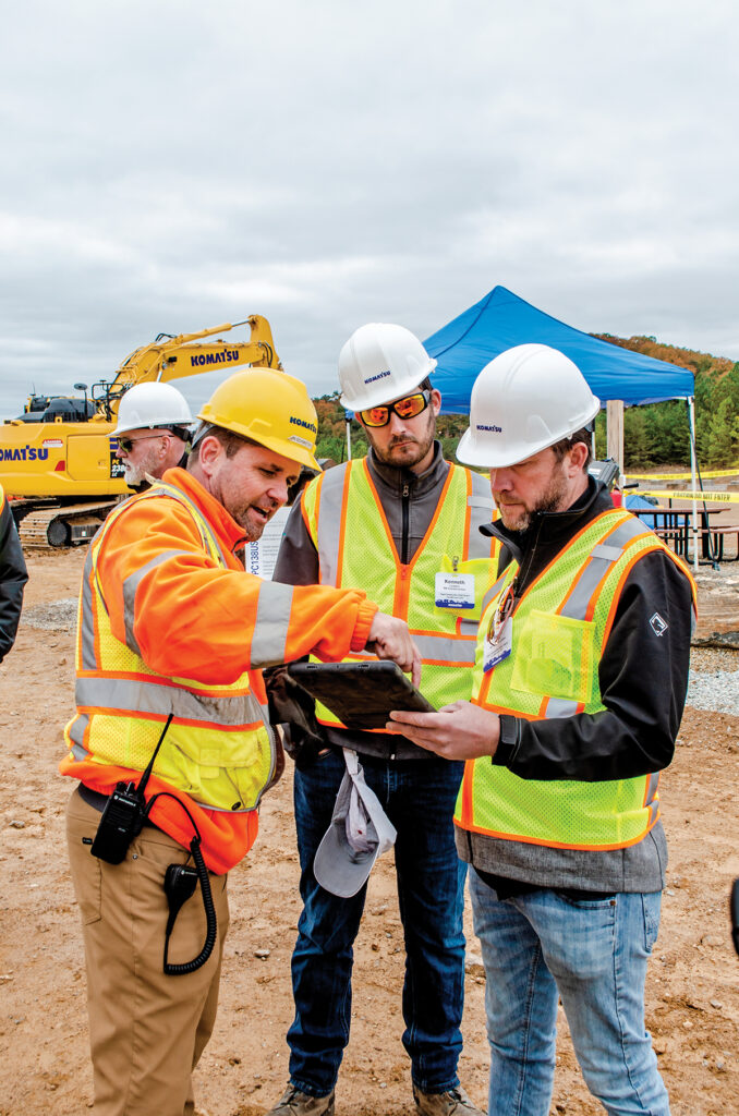 Three attendees access Smart Construction Remote on a tablet at Komatsu’s Smart Construction and Smart Quarry Demo Days