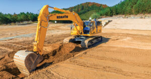 An operator cuts a ditch with a Komatsu PC490LCi-11 intelligent Machine Control (iMC) 2.0 excavator.