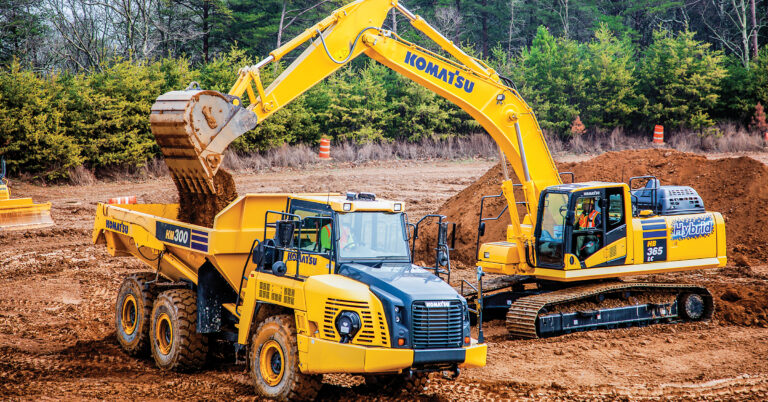 Komatsu's Hybrid HB365LC-3 excavator loading dirt into a Komatsu HM300 truck