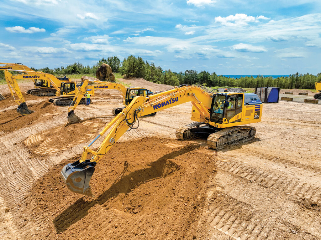 An attendee tries out a Komatsu PC210LCE electric excavator
