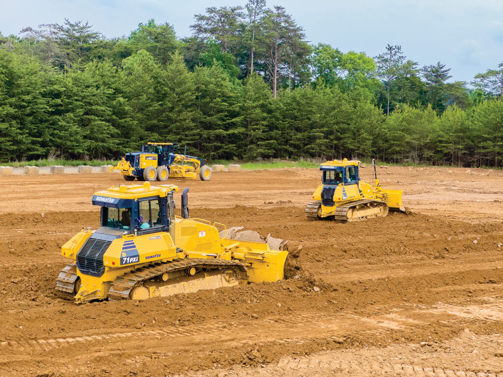 Operators move material with Komatsu D71PXi and D51PXi Intelligent Machine Control (IMC) 2.0 dozers, while another operator utilizes a Komatsu GD655-6 motor grader.