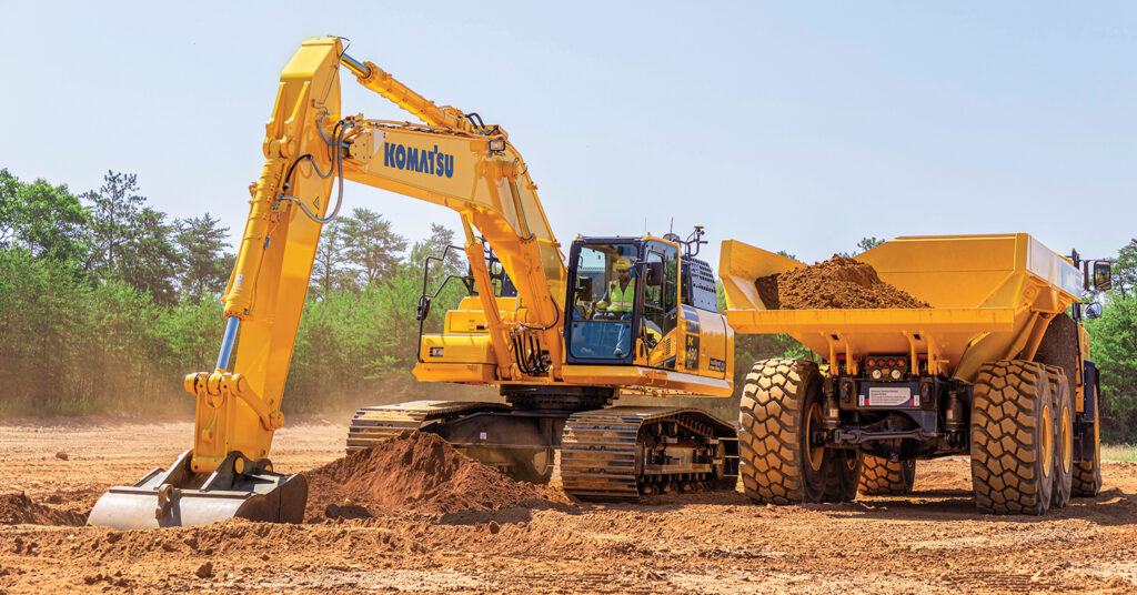 Director of Digital Solutions Adrien Clapp's article on Komtrax telematics is highlighted with this image of a Komatsu truck and a Komatsu PC490LCi excavator moving dirt